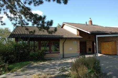 Der Kindergarten Vogelsang steht zwischen Bäumen eingebettet neben dem Schulhaus Singvogel.