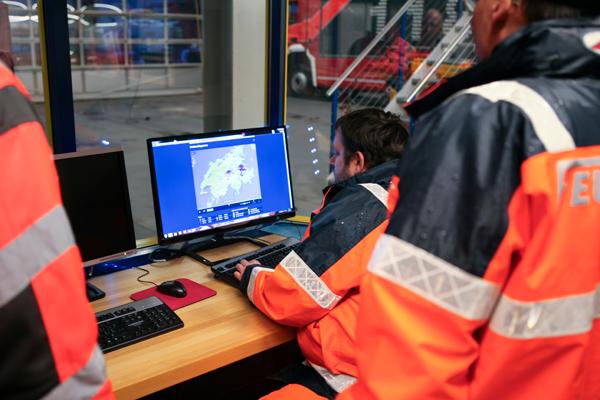 Auf der Zentrale beobachten Feuerwehrleute die Wetterentwicklung auf dem Radarbild.