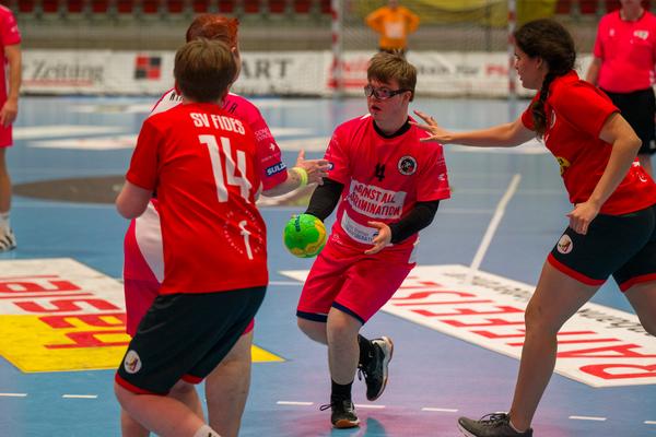 Menschen in Turnhalle beim Handballspiel.