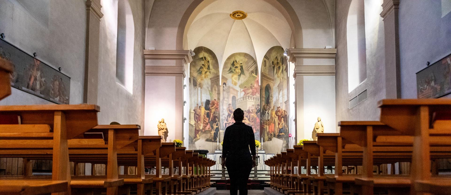 Personne qui entre dans l'église de Saillon