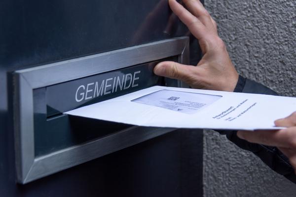 Ein Stimmcouvert wird in den Briefkasten der Gemeinde eingeworfen.